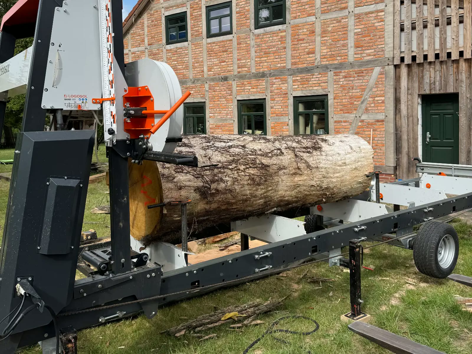 Mobiles Sägewerk schneidet einen Eichenstamm zu Bohlen